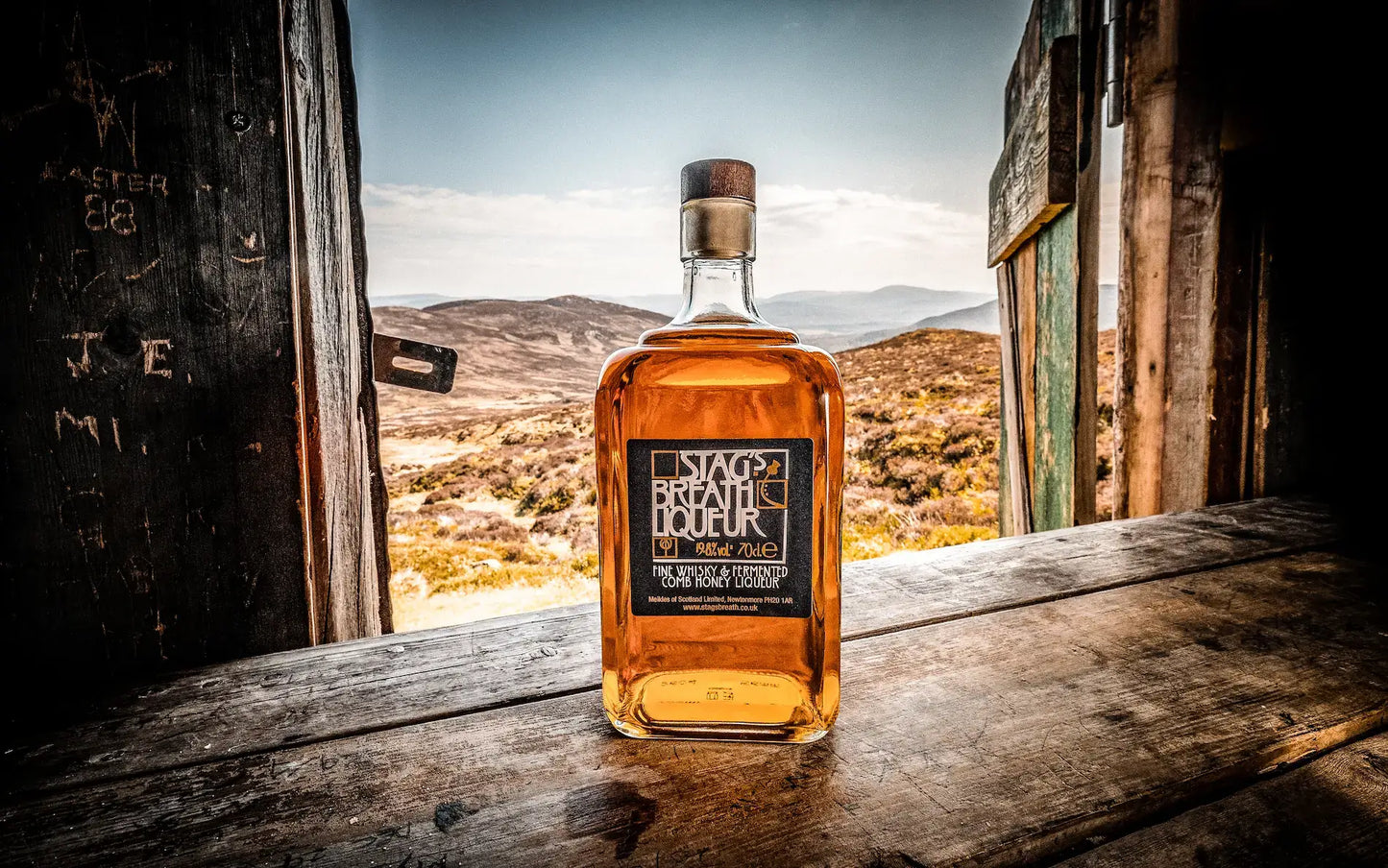 bottle of Stag's Breath Scottish Honey Whisky Liqueur In window of a broken down shack in scottish wilderness