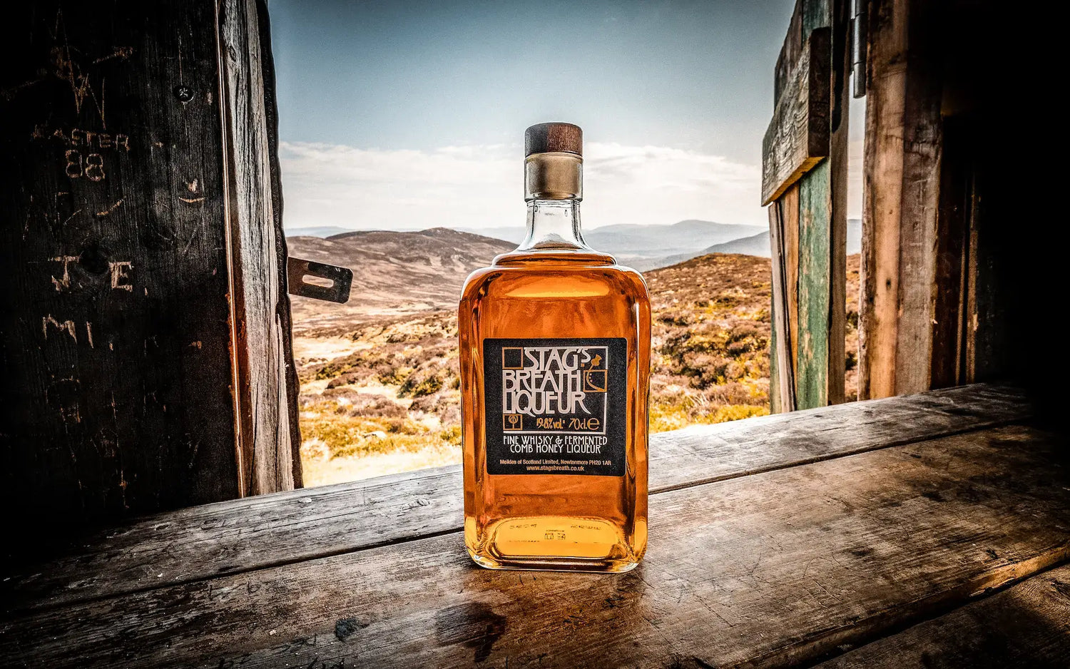bottle of Stag's Breath Scottish Honey Whisky Liqueur In window of a broken down shack in scottish wilderness